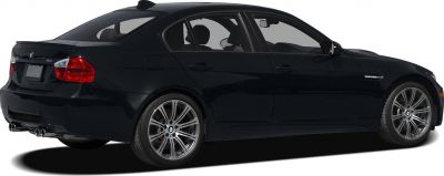 Black sedan rear side view with alloy wheels and quad exhaust