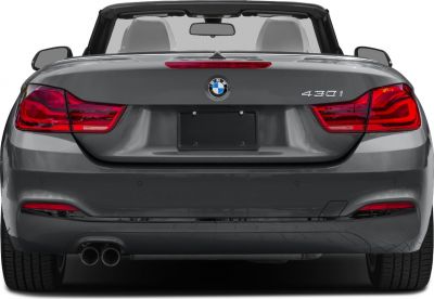 Convertible rear view with distinctive tail lights and dual exhaust.
