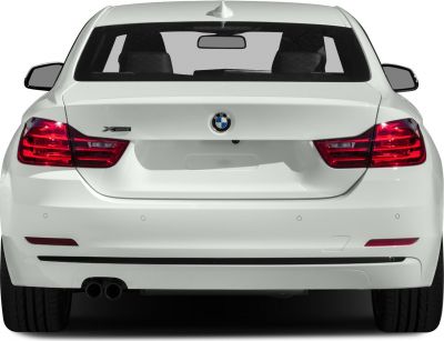 Rear view of white sedan with xDrive badge and dual exhaust