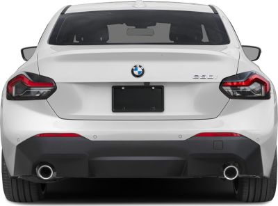 Rear view of a white coupe with distinctive taillights and dual exhaust pipes