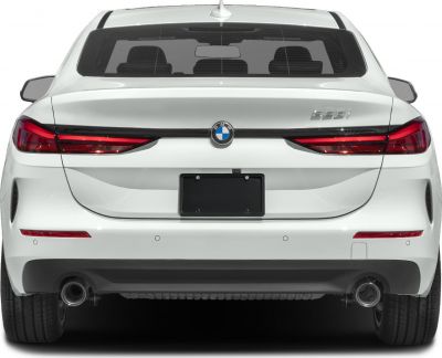 Rear view with sleek taillights and dual exhaust of white coupe sedan