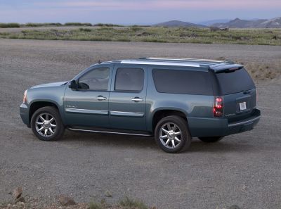 Side view of extended SUV with tinted windows, chrome wheels, and roof rails