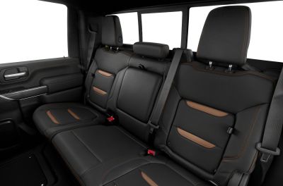 Rear black leather seats with brown accents, headrests, and seat belts