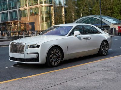 Luxury white sedan with prominent front grille and multi-spoke alloy wheels