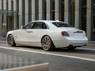 Rear-side view of white luxury sedan with multi-spoke alloy wheels