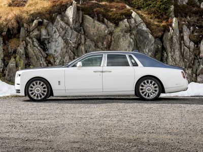 Sleek luxury sedan side profile with two-tone roof and multi-spoke premium wheels