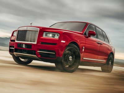 Luxury SUV with prominent front grille and LED headlights in dynamic motion