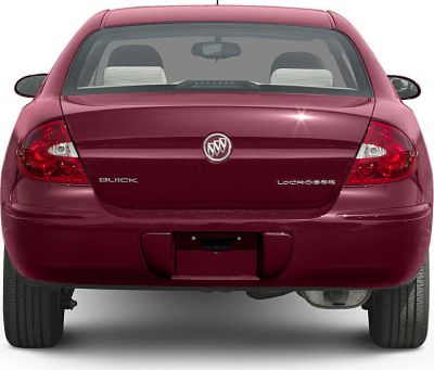 Rear view showcasing taillights and emblem badges of a sedan.