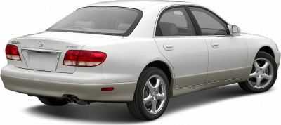 Rear and side view of white four-door sedan with alloy wheels