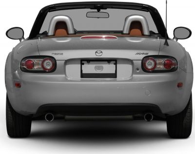 Rear view showing taillights, twin exhausts, and roll bars of convertible sports car