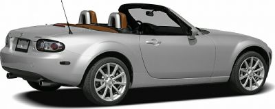 Silver convertible sports car with dual exhausts and alloy wheels.