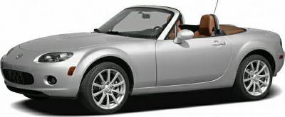 Silver convertible roadster with aerodynamic design and brown leather interior.