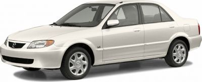 Front side profile of a white sedan with distinct headlights and wheel design.