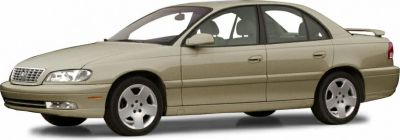 Side view of beige sedan with alloy wheels and rear spoiler