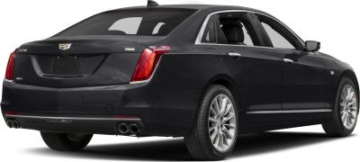Black sedan rear quarter view with dual exhaust and alloy wheels