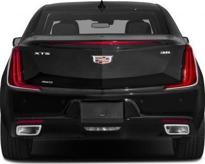 Rear view with vertical LED taillights, dual exhaust outlets, and luxury emblem