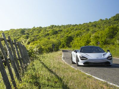 Front aerodynamic design with sleek headlights on winding road