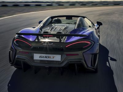 Rear view featuring active spoiler and sleek taillights on a convertible sports car.