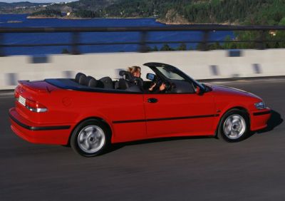 Red convertible with soft top roof and alloy wheels.