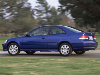 Blue coupe side profile with VTEC emblem driving on road