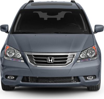 Front view of a minivan grille, headlights, and fog lights