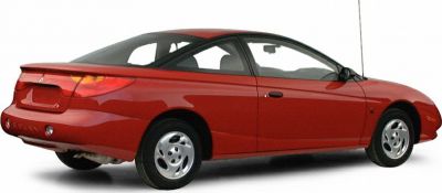 Red two-door coupe rear side view with steel wheels and smooth body design