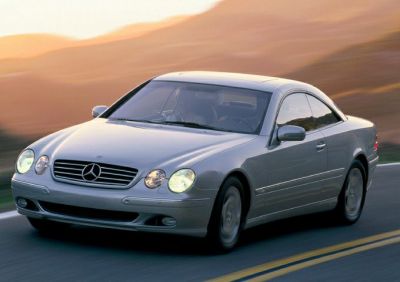 Silver coupe front view with dual circular headlights in motion