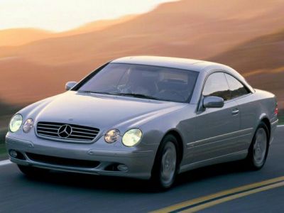 Front side view of a silver coupe with dual round headlights