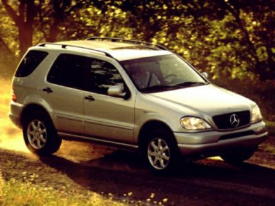 Silver SUV driving on a forest dirt trail in off-road conditions