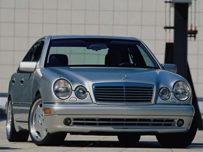 Front view of a silver luxury sedan with distinctive quad round headlights and wide grille.