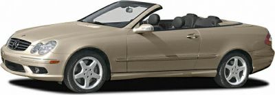 Side view of a beige convertible with alloy wheels and soft top.