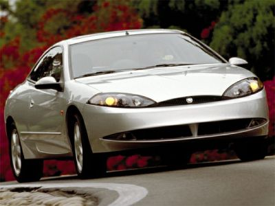 Front view of sleek coupe with headlights on