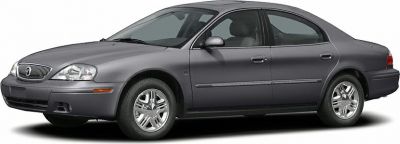 Side view of a gray four-door sedan with chrome alloy wheels.