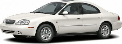 Side view of a white 4-door sedan with smooth body lines and chrome wheels