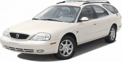Front side view of a white station wagon with roof rails