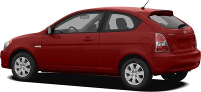 Side profile of a compact red hatchback with alloy wheels and rear spoiler