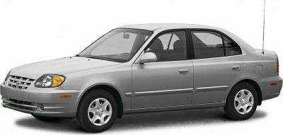 Side profile of a silver compact four-door sedan with alloy wheels and a streamlined body.