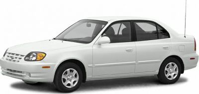 Side profile of a white compact sedan with alloy wheels
