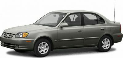 Side-front view of a four-door compact sedan with rounded headlights and silver paint.