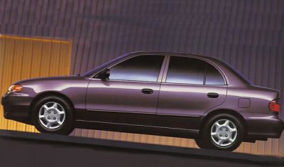 Side profile of a four-door compact sedan with smooth contours and alloy wheels