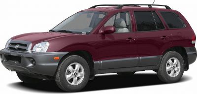 Front side view of maroon mid-2000s SUV with alloy wheels