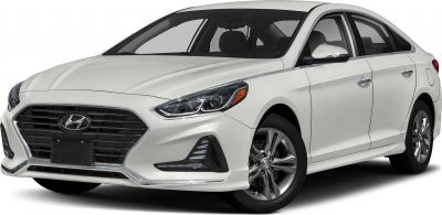 Front grille and headlight details with alloy wheels on a white sedan