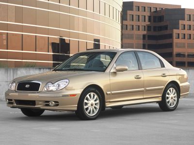 Front-side view of sedan with distinct headlights and alloy wheels