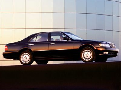 Side view of a sleek luxury sedan with classic 1990s design and alloy wheels