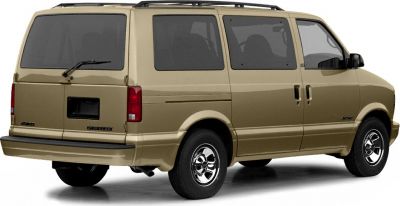 Rear-side view of a beige 1985 minivan with sliding doors and large windows