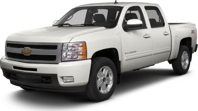 Front-side view of white crew cab pickup with dual headlamps and standard box