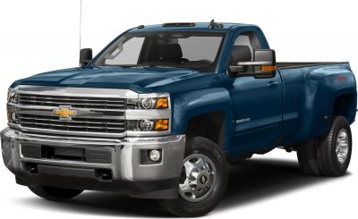 Front-side view of heavy-duty pickup with dual rear wheels and chrome grille.