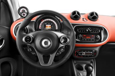 Steering wheel with controls and dashboard featuring speedometer, air vents, and infotainment system.