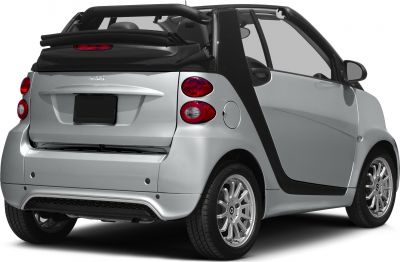 Compact convertible with folded soft top, round taillights, and silver alloy wheels