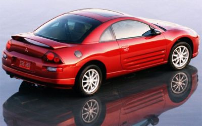 Red coupe with rear spoiler, side air vents, and sporty design.